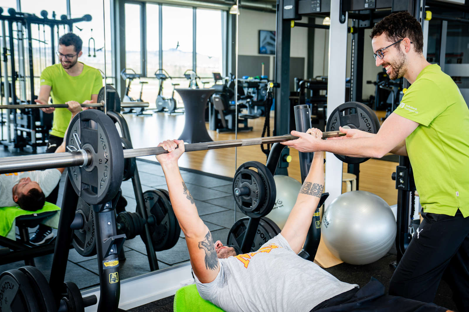 Hilfe beim Gewichtheben durch Trainer im Sportpuunkt