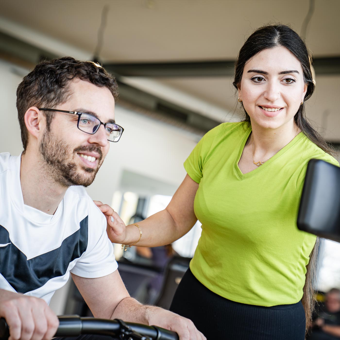Beratung beim Rudergerät durch Fitnesstrainerin